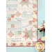 A closer look at the lower right corner of the quilt, showing layout details as coordinating decor peeks into frame.