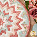 A top down shot of half the topper, showing fabric color and prints; coordinating flowers peek into frame from the upper right corner.