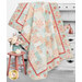 A shot of the completed quilt in pink, blue, and cream fabrics from the Muse collection by Moda Fabrics, artfully draped over a faded armoire and staged with coordinating flowers and furniture.