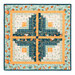 The completed Log Cabin Wall Hanging colored in aqua, navy blue, cream, and orange fabrics, isolated on a white background.