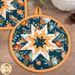 A close up on the round hot pad, demonstrating color and print details on the blue, cream, and orange fall-themed fabrics.