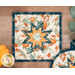 A close up on the sqaure hot pad, demonstrating color and print details on the cream, blue, and orange fall-themed fabrics.