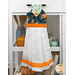 The Hanging Towel, colored in aqua, blue, and orange fabrics from the I Love Fall Most of All collection, staged on a white kitchen drawer with coordinating decor.