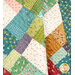 A close-up on the patchwork while the quilt is draped, showing how the colors and cuts contrast while showcasing the floral top quilting details.