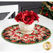 The topper staged on a white table, set with a white vase of red roses on top.