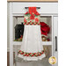The Hanging Towel, colored in cream, green, and red fabrics from the Cardinal Celebration collection, staged on a white kitchen drawer with coordinating decor.
