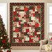 A shot of the completed Easy as ABC quilt in red, black, green, and cream fabrics from the Cardinal Celebration collection by Wilmington Prints, hung on a tan wall and staged with coordinating flowers and furniture.