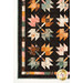 A closer look at the patchwork leaves and inner border of the lower left corner of the quilt, showing fabric color and print details.