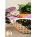 A close up photo of a bowl cozy with a bowl inside, showing usage, while a blurred stack of other coordinating cozies and decor sit in the background.