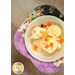 A top-down image of a bowl of vanilla ice cream covered in candy corn, set inside of a bowl cozy.