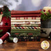 A stack of the fabrics included in the Christmas Tails FQ Bundle, with a candle and a bell and ornaments and thread.