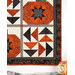 A closer look at the lower left flying geese block of the wall hanging, demonstrating details and colors on the orange, black, and cream fabrics.