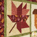 A close up on one of the patchwork leaves, showing details on the fabric colors and prints as well as top quilting effects.