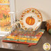 The completed Dry Ideas drying mat, colored in soft autumn fabrics from the Harvest Blooms collection. The project is staged on a kitchen counter with coordinating fall decor.