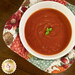 A top down shot of a bowl full of tomato soup in one of the bowl cozies.