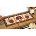 A shot of the project as a table runner, displayed horizontally on a wooden table set with coordinating autumnal decor.