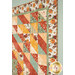 An angled shot of the quilt, demonstrating fabric layout, prints and colors, as well as details on the borders and binding.