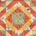 A close up on the center patchwork of the quilt, demonstrating fabric color and print details that guide the eye around the concentric diamonds.
