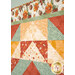 An angled close up on the patchwork of the quilt, demonstrating fabric color and print details.