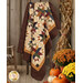 A shot of the Woven Dreams quilt hung over a wooden ladder and staged with coordinating primitive autumnal décor.