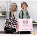 Two smiling models (Lynn and Tammy) demonstrating usage of the pink tote bags.