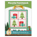 Front cover of the pattern showing the completed project depicting trees and presents in red, blue, green, and white fabrics, staged on a white paneled wall with coordinating Christmas décor.
