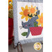 A closer look at the cat, demonstrating details on the hand stitched face and appliqué flowers.