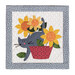The completed On Wander Lane Mini Quilt for August, a cute gray cat with a pink nose, crossing through a pot of yellow flowers, isolated on a white background.