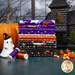 A stack of the fabrics included in the Ghostly Soiree collection with a Mansion and a pumpkin and a ghost and candycorn and thread.