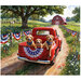 Panel fabric featuring a red truck with dogs in the back on a dirt drive in the country and red barn with an Americana theme.
