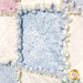 A super close up on one of the quilt blocks, demonstrating details on the fabric, top quilting, and the frayed rag seams of the project.