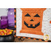 A super close up on one of the orange spool blocks with a jack-o'-lantern smile, showing fabric colors and top stitching details.