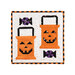 The completed October project featuring two orange spool blocks as trick-or-treat bags with jack-o'-lantern faces and candy, isolated on a white background.