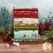 A stack of the flannel fabrics included in the Snowtop Mountain Flannel collection, with trees and snow and garlands and cardinals and thread.