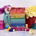 A stack of the fabrics included in the Kipling Gardens collection with flowers and a pot and jars and thread.