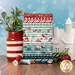 A stack of the fabrics included in the A Perfect Winter collection, with snowflakes and a jar and mistletoe and an ornament and a ceramic house and thread.