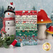 A stack of the fabrics included in the Country Christmas collection, with trees and snow and a snowman and Mushrooms and mistletoe and thread.