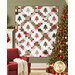 The completed Evergreen Quilt colored in red, white, and green fabrics from the Berry & Pine collection by Moda Fabrics, hung on a green wall and bordered by coordinating festive décor.