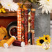 A stack of the fabrics included in the Homestead Harvest collection with a truck and pumpkins and flowers and a jug and leaves and thread.