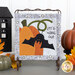 The completed On Wander Lane Mini Quilt for October, an appliqué pumpkin and bat beside hand-stitched text that reads 