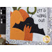 A super close up on the appliqué bat hanging upside down, beside hand-stitched text that reads 