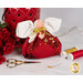The completed July Birthstone Angel with a ruby red palette, white wings, a gold bow and vivid red charm beside coordinating decor and notions.
