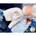 Detail shot of the angel, highlighting the metallic effect of the wings and the angel's metallic silver bow featuring a deep blue charm that resembles a blue sapphire in a golden setting.