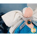 Detail shot of the angel, highlighting the metallic effect of the wings and the angel's metallic silver bow featuring a bright blue charm that resembles a zircon in a golden setting.