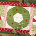 A super close up on the green wreath, showing fabric colors and print details.