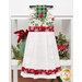 The completed hanging towel staged on a kitchen drawer, colored in cream, green, and red fabrics from the Mistletoe & Holly collection. Coordinating festive decor peeks in from behind the towel.