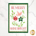 Holiday tea towel with “Be Merry, Shine Bright” text and a bird, ornaments, and holly wreath.