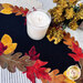 A top down shot of the mat with a white candle staged on the center as coordinating decorative florals peek into frame.