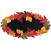 The completed Falling Leaves wool mat, a black mat framed by contrasting red, orange, yellow, and brown falls leaves, isolated on a white background.