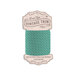 Spool of turquoise fabric with vertical white dashes and a pattern of dark teal lines bias tape isolated on a white background